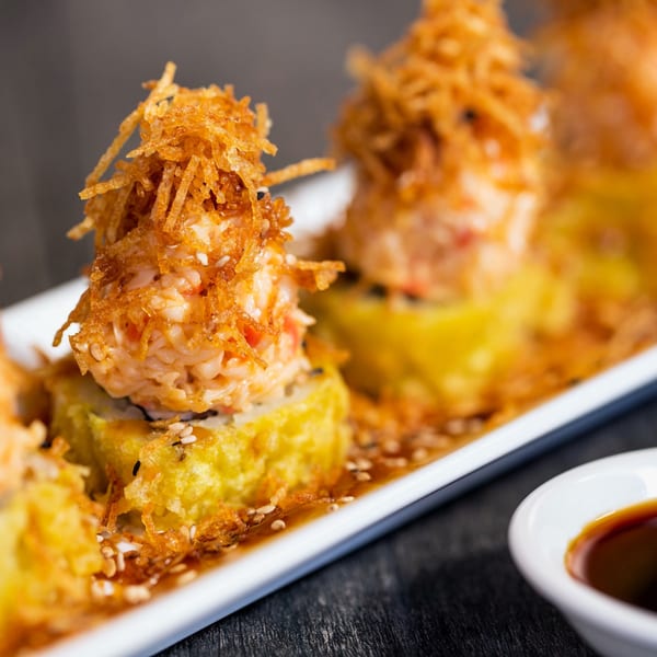 Four crispy, golden-fried sushi rolls topped with spicy crab and crunchy fried potato strings.
